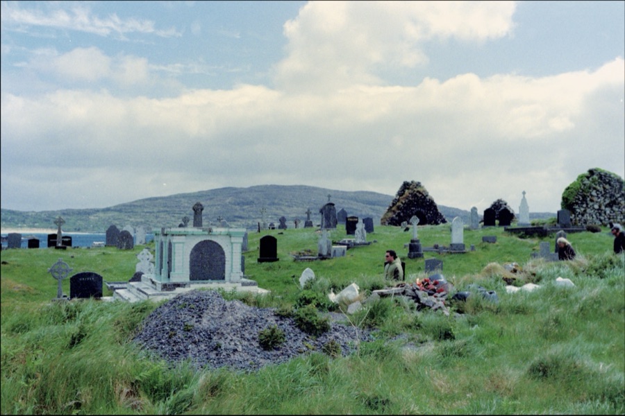 A hillside graveyard of weathered headstones above the sea