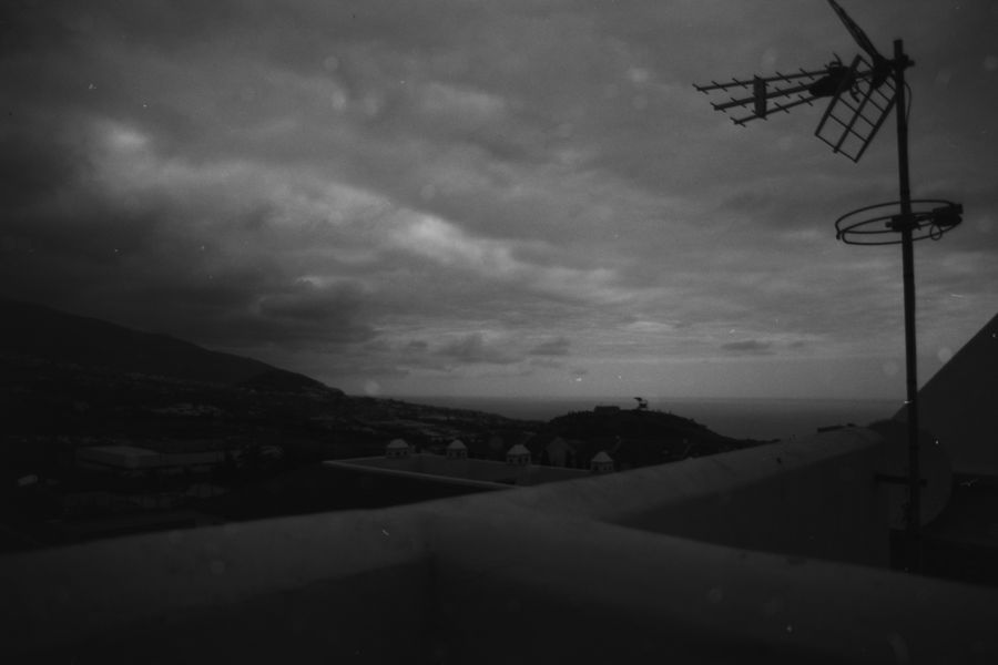 A rooftop antenna above the coast at dusk
